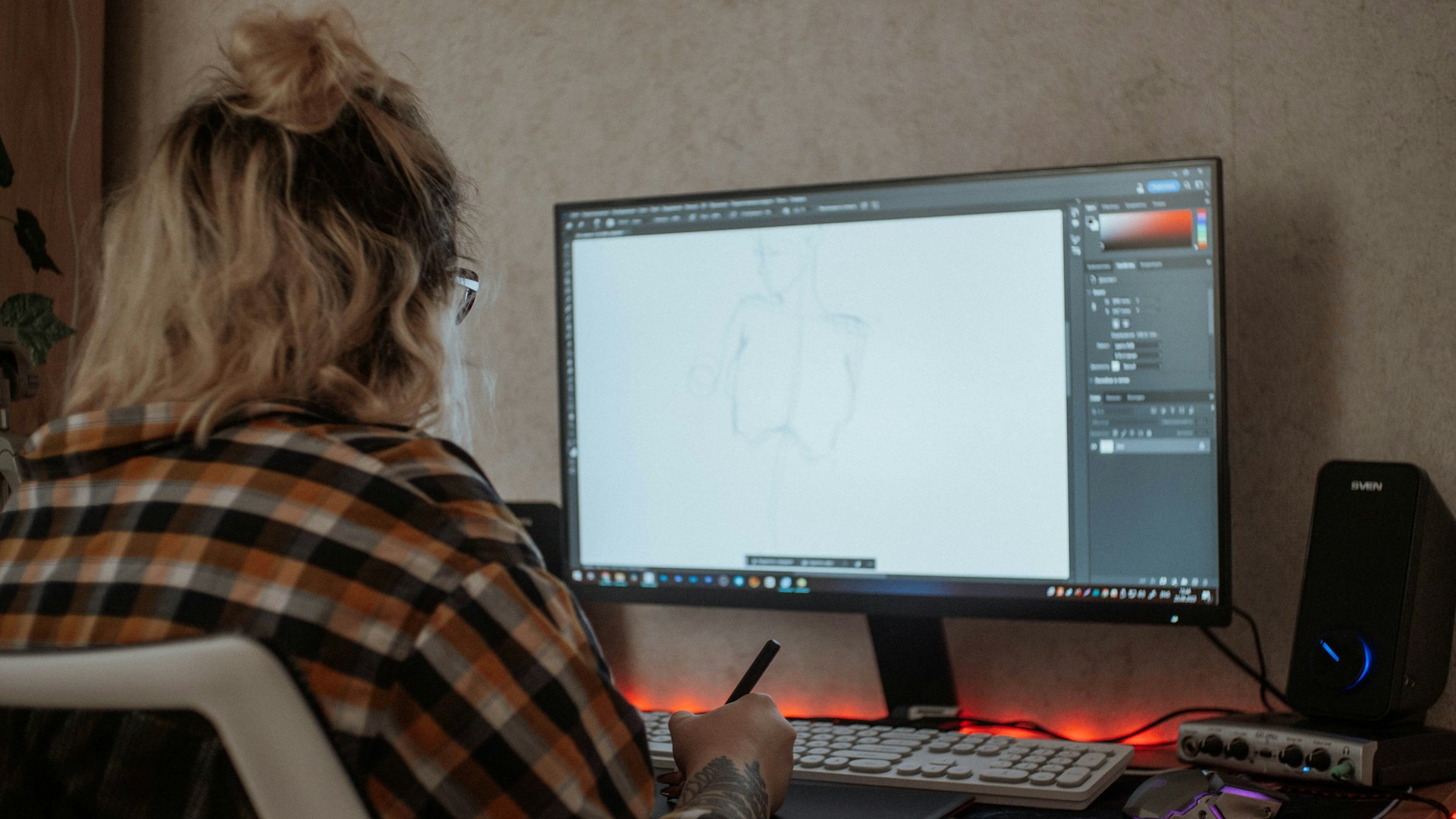 a woman sitting in front of a computer monitor